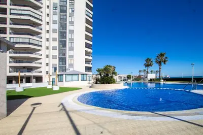a swimming pool in front of a large apartment building at ESPACIO 3 - Primera Línea de Playa in Cullera