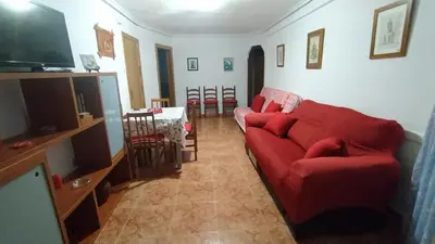 a living room with a red couch and a television at Apartamento Playero in Tavernes de Valldigna