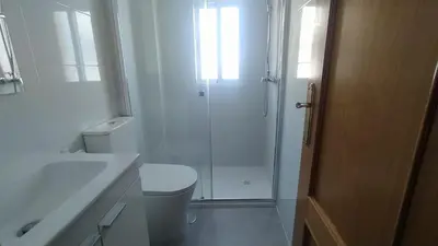 a white bathroom with a shower and a toilet at Apartamento Playero in Tavernes de Valldigna