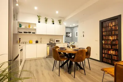 a kitchen and dining room with a table and chairs at Portrait Boutique Apartment in Valencia