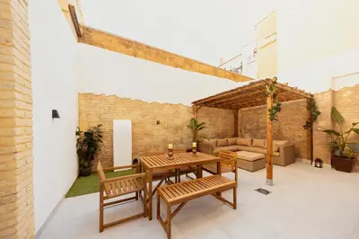 an outdoor patio with a wooden table and benches at Portrait Boutique Apartment in Valencia