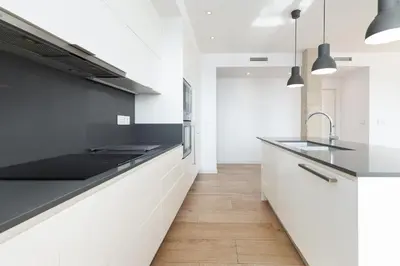 a kitchen with black and white counters and a sink at ApartUP Patacona Deluxe in Valencia