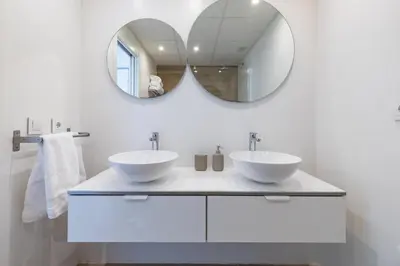 a white bathroom with two sinks and a mirror at ApartUP Patacona Deluxe in Valencia