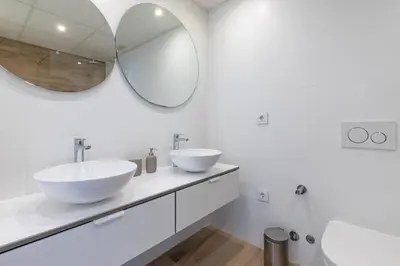 a white bathroom with two sinks and a mirror at ApartUP Patacona Deluxe in Valencia