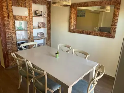 a white table and chairs in a room with a mirror at Playa y cultura en el Cabanyal Alquiler de temporada familiar in Valencia