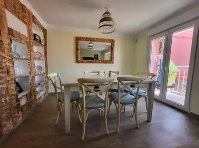 a dining room with a table and chairs and a mirror at Playa y cultura en el Cabanyal Alquiler de temporada familiar in Valencia