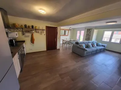 a living room with a couch and a kitchen at Playa y cultura en el Cabanyal Alquiler de temporada familiar in Valencia