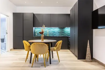 a dining room with a table and yellow chairs at Suite Deluxe Valencia - AIORA Apartments in Valencia