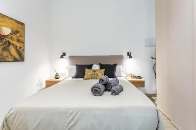 a bedroom with a large white bed with two stuffed animals on it at Suite Deluxe Valencia - AIORA Apartments in Valencia