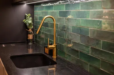 a kitchen with a sink and a green tiled wall at Suite Deluxe Valencia - AIORA Apartments in Valencia