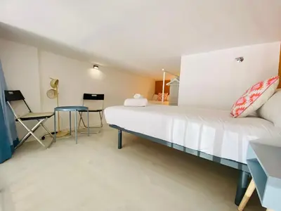a bedroom with a large bed and a table at Modern Designed Loft in Russafa (SOHO) in Valencia