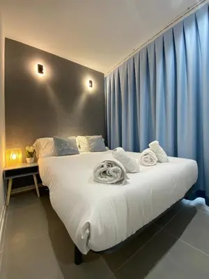 a bedroom with a large white bed with towels on it at Modern Designed Loft in Russafa (SOHO) in Valencia