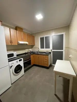 a kitchen with a white refrigerator and a white table at UIM Mediterraneo PB Miguel Hernandez Wifi in Puerto de Sagunto