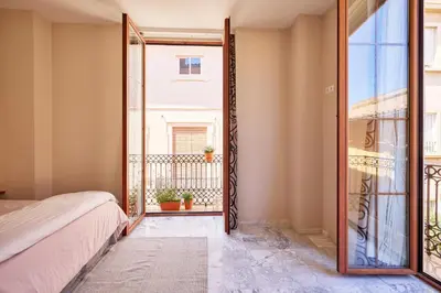 a wooden door leading to a hallway with a table at Citizentral Juristas in Valencia