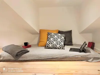a bed with pillows and a laptop on top of it at lifecoliving valencia loft BR in Valencia