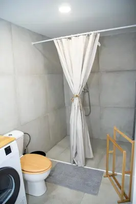 a bathroom with a shower with a toilet and a shower curtain at lifecoliving valencia loft BR in Valencia