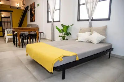 a bedroom with a bed with a yellow blanket on it at lifecoliving valencia loft BR in Valencia