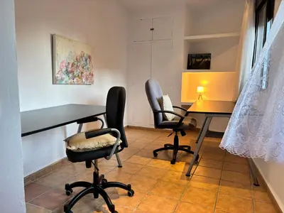 a room with two desks and chairs and a table at Piso en Vall de Almonacid con vistas, aire acondicionado, Wifi y Smart TV in Vall de Almonacid