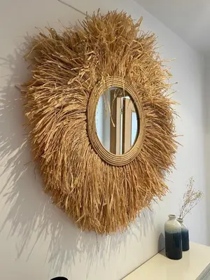 a round mirror on a wall with a pile of hay at SingularStays El Grao in Valencia