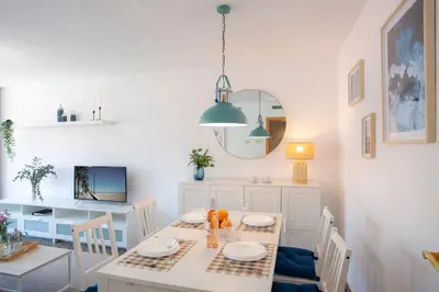 a white dining room with a table and chairs at SingularStays El Grao in Valencia