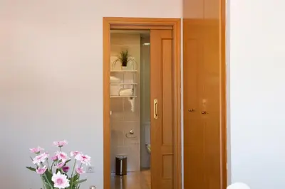 a bathroom with a door and a vase of flowers at SingularStays El Grao in Valencia