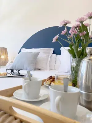 a tray with cups and plates on a table next to a bed at SingularStays El Grao in Valencia