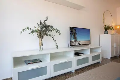a living room with a white entertainment center with a tv at SingularStays El Grao in Valencia