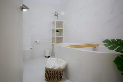 a white bathroom with a tub and a basket at SingularStays Tinglado in Valencia