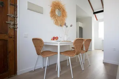 a dining room with a white table and chairs at SingularStays Vivons in Valencia