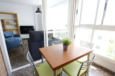 a living room with a wooden table and chairs at Playa Malvarrosa House in Valencia