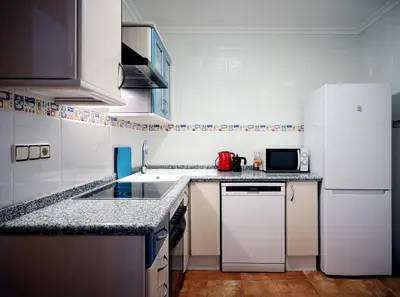 a kitchen with white appliances and a white refrigerator at Cozy apartment near the center, Torres de Serrano in Valencia