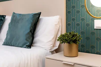 a bed with a pillow and a plant on a night stand at Anelsa Torres de Serranos 3 in Valencia