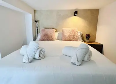 a bedroom with a white bed with towels on it at Exclusive LOFT in Ruzafa (SOHO) in Valencia