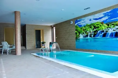 a swimming pool with a waterfall mural on the wall at Casa Navajas in Jérica