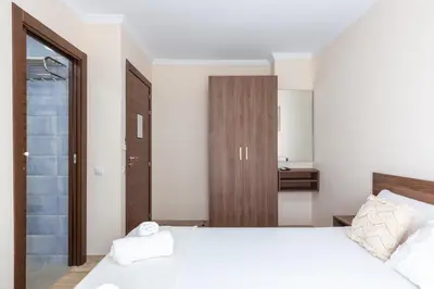 a bedroom with a large white bed and a bathroom at Casa Navajas in Jérica