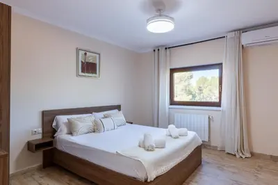 a bedroom with a bed with white sheets and a window at Casa Navajas in Jérica