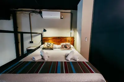 a bedroom with a bed with two pillows and two beds sidx sidx at Apartment Ruzafa Roots, 12 min to Centre, Smart TV, Wine in Valencia