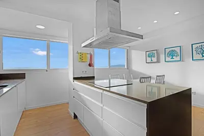 a kitchen with white cabinets and a counter top at Apartamento atardecer dorado in Valencia