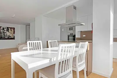 a white kitchen with a white dining table and chairs at Apartamento atardecer dorado in Valencia