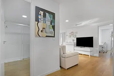a white living room with a couch and a television at Apartamento atardecer dorado in Valencia
