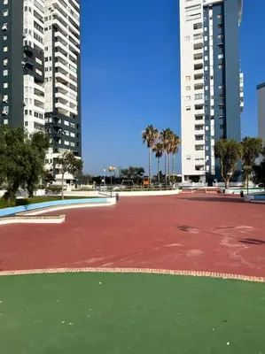 a red tennis court in a city with tall buildings at Apartamento atardecer dorado in Valencia