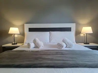 a large white bed with pillows and two lamps at MAGNIFICO APARTAMENTO · PLAYA CANET DE BERENGUER in Canet de Berenguer