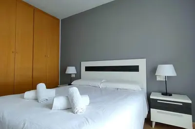 a bedroom with a large white bed with towels on it at MAGNIFICO APARTAMENTO · PLAYA CANET DE BERENGUER in Canet de Berenguer
