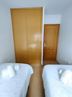 a bedroom with two beds and a wooden door at MAGNIFICO APARTAMENTO · PLAYA CANET DE BERENGUER in Canet de Berenguer