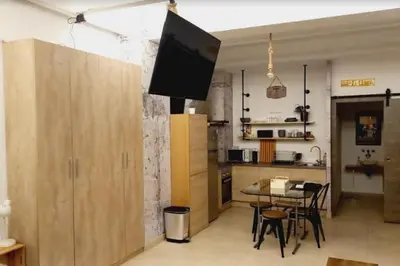 a kitchen with a table and a tv on a wall at Loft Botanic Center in Valencia
