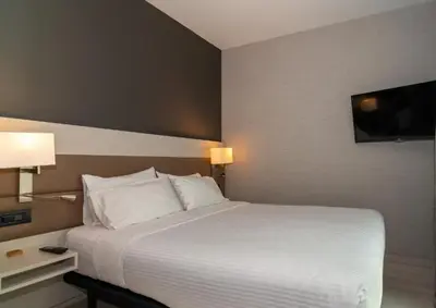 a bedroom with a large white bed and a television at SH Colón Valencia in Valencia