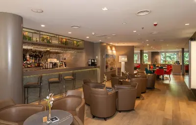 a restaurant with brown chairs and a bar at SH Colón Valencia in Valencia
