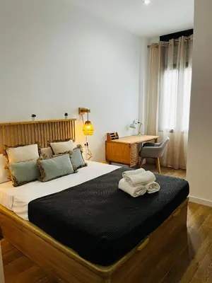 a bedroom with a large bed with two towels on it at Travel Habitat Mediterranean Suites in Valencia