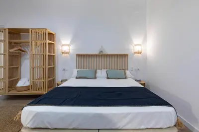 a bedroom with a large bed with two blue pillows at Travel Habitat Mediterranean Suites in Valencia