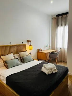 a bedroom with a large bed with two towels on it at Travel Habitat Mediterranean Suites in Valencia